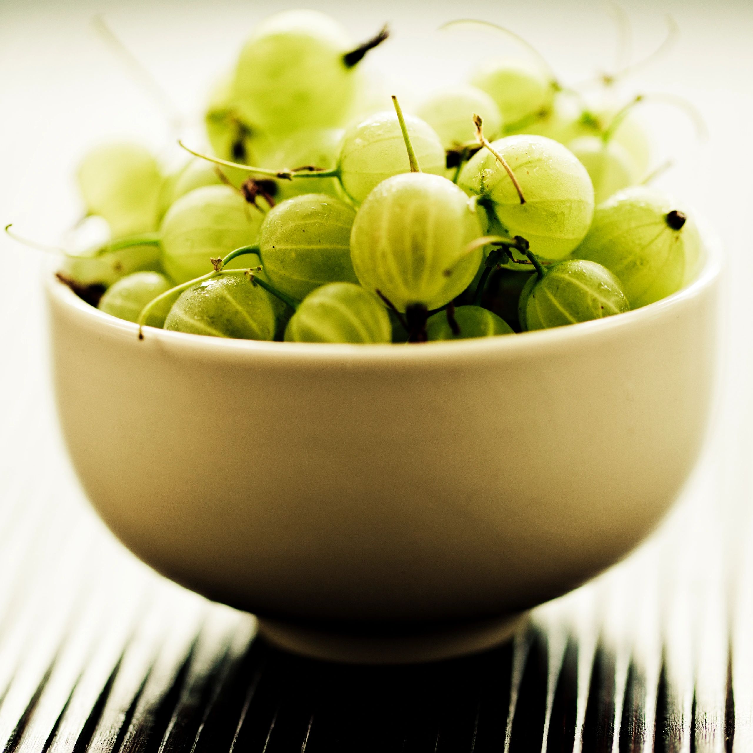 Fresh amla gooseberries in a white bowl